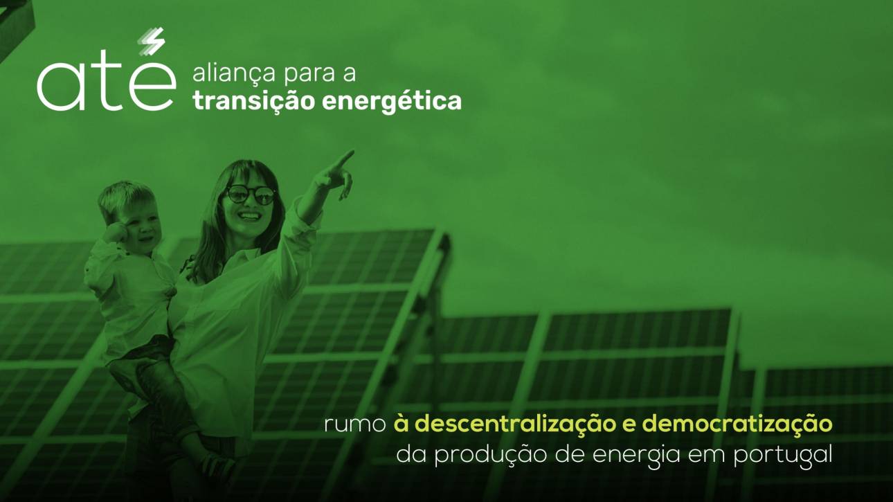Woman holding a child, solar pannels behind them